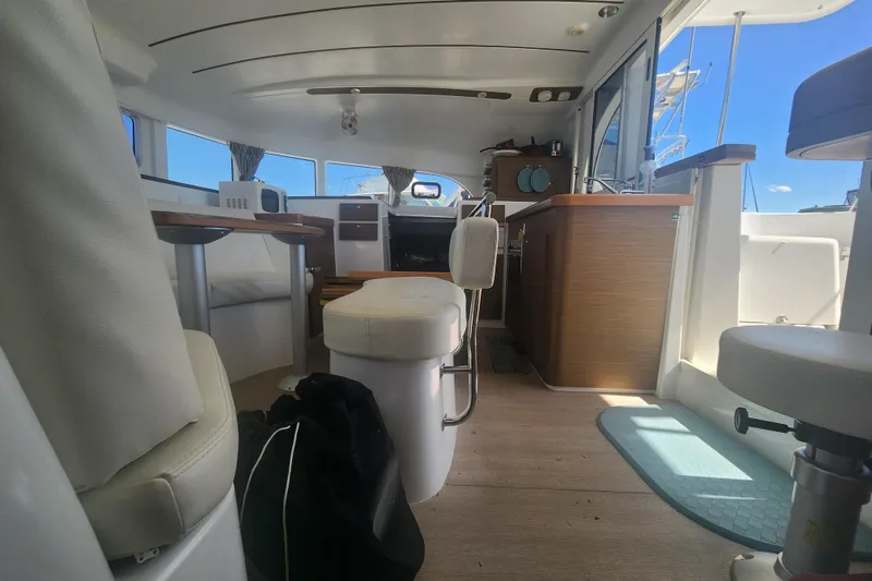 Slide: The Image of Interior of a 2019 Lagoon 380 catamaran, featuring modern seating and a compact kitchen area. - 6