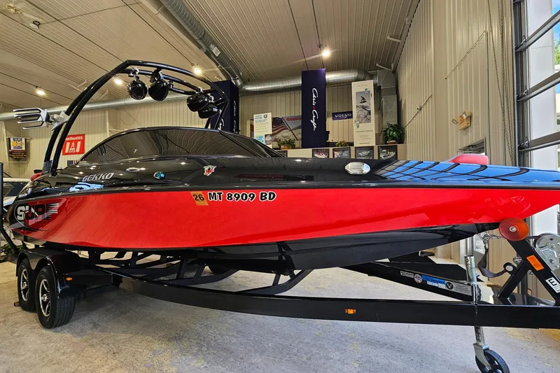 The Image of 2017 Gekko Revo 7.1 boat in showroom, red and black design, on trailer. - 1