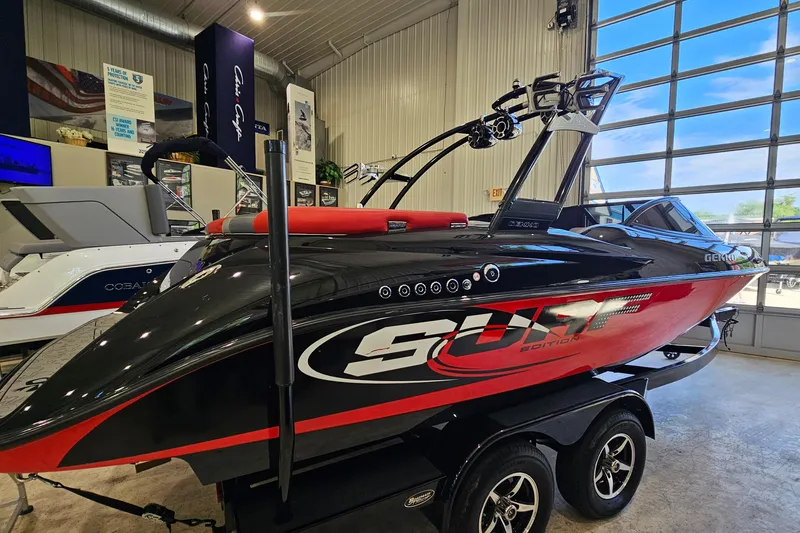 Slide: The Image of 2017 Gekko Revo 7.1 Surf Edition boat in showroom, black and red design. - 24