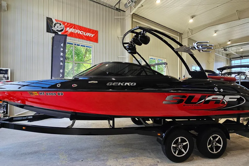 Slide: The Image of 2017 Gekko Revo 7.1 Surf Edition boat in showroom, red and black design. - 3