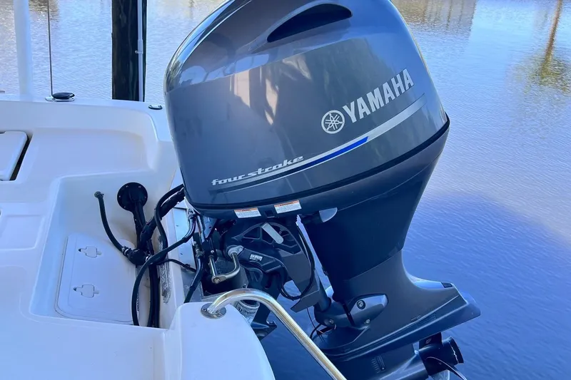 Slide: The Image of Yamaha four-stroke engine on 2016 NauticStar 2110 Sport boat, docked by water. - 20