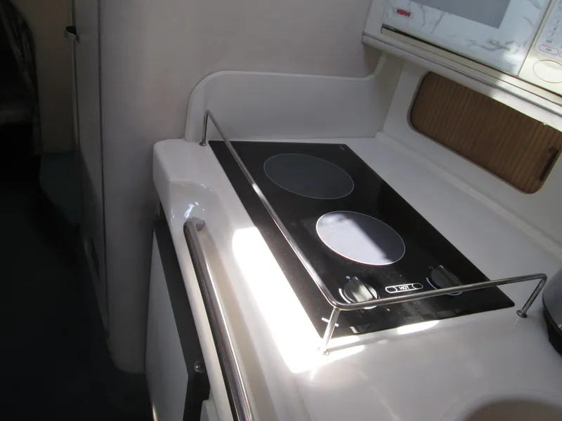 Slide: The Image of 1996 Sea Ray 290 Sundancer kitchen area with stove. - 30
