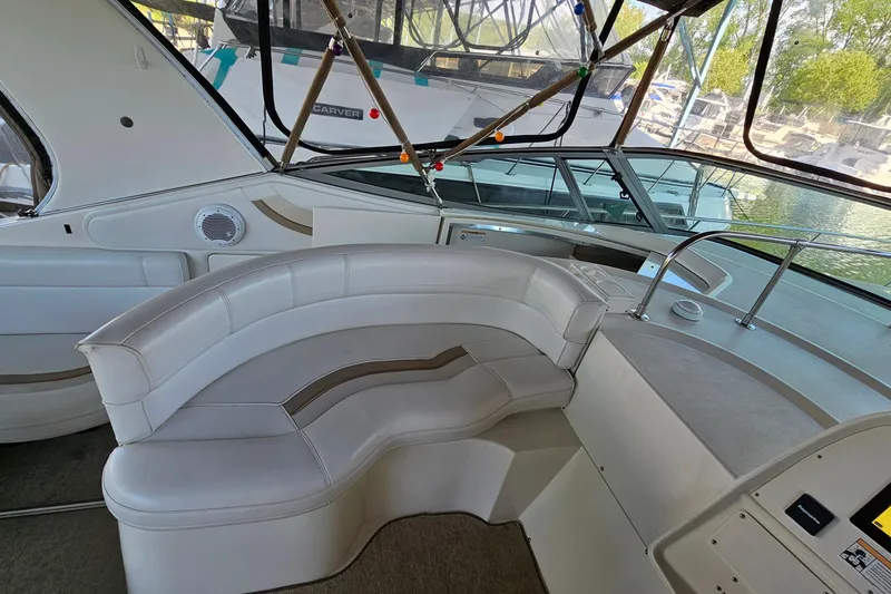 Slide: The Image of 1996 Cruisers Yachts 3570 Esprit interior with white seating and helm, docked by water. - 10