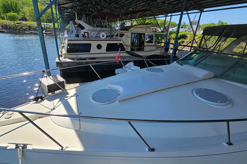 Slide: The Image of 1996 Cruisers Yachts 3570 Esprit docked under a covered marina, sunny day. - 4