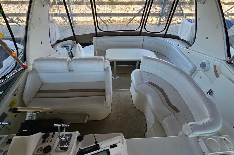 Slide: The Image of Interior of a 1996 Cruisers Yachts 3570 Esprit with white seating and helm controls. - 6