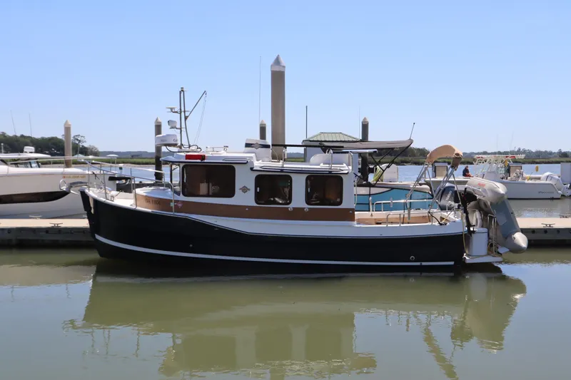 The Image of 2015 Ranger Tugs R-27 boat docked at marina, calm water reflection. - 0