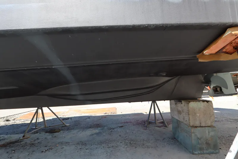 Slide: The Image of 2015 Ranger Tugs R-27 boat hull on stands, showing underside details. - 10