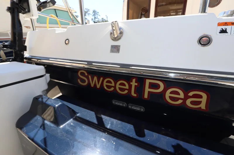 Slide: The Image of 2015 Ranger Tugs R-27 boat named "Sweet Pea" with white and blue exterior. - 17