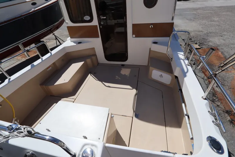 Slide: The Image of 2015 Ranger Tugs R-27 boat deck with seating and storage compartments. - 18