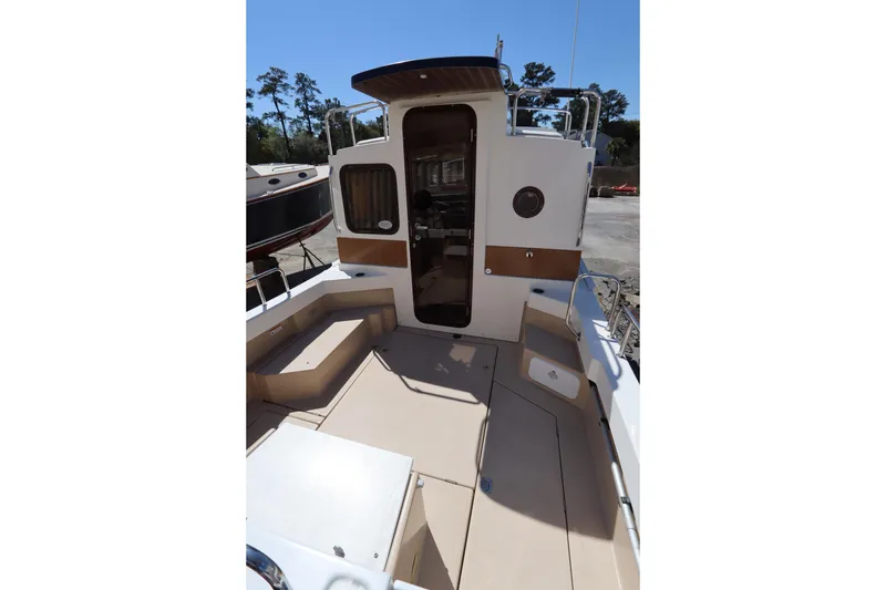 Slide: The Image of 2015 Ranger Tugs R-27 boat deck with seating and entry door. - 19