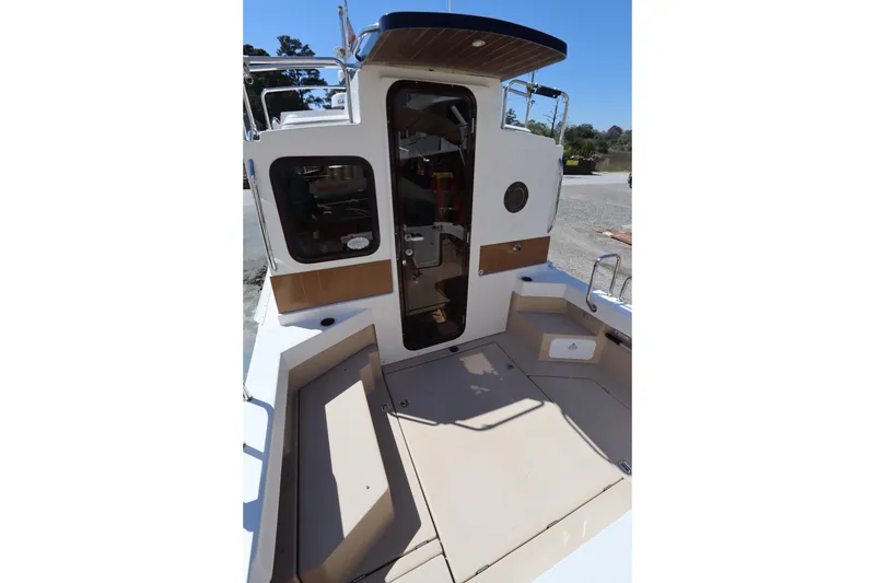 Slide: The Image of 2015 Ranger Tugs R-27 boat cockpit with seating and entry door. - 21