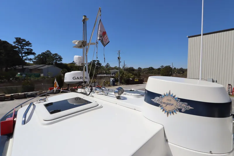 Slide: The Image of 2015 Ranger Tugs R-27 boat rooftop with equipment and logo under clear blue sky. - 27