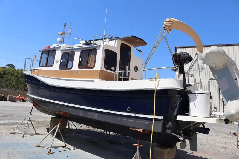 Slide: The Image of 2015 Ranger Tugs R-27 boat on stands, blue and white hull, outdoor setting. - 3