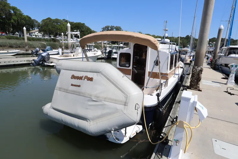 Slide: The Image of 2015 Ranger Tugs R-27 docked, featuring "Sweet Pea" name and covered rear deck. - 47