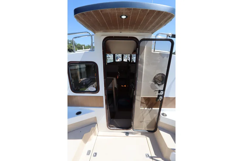 Slide: The Image of 2015 Ranger Tugs R-27 boat entrance with open glass door and wooden ceiling. - 62