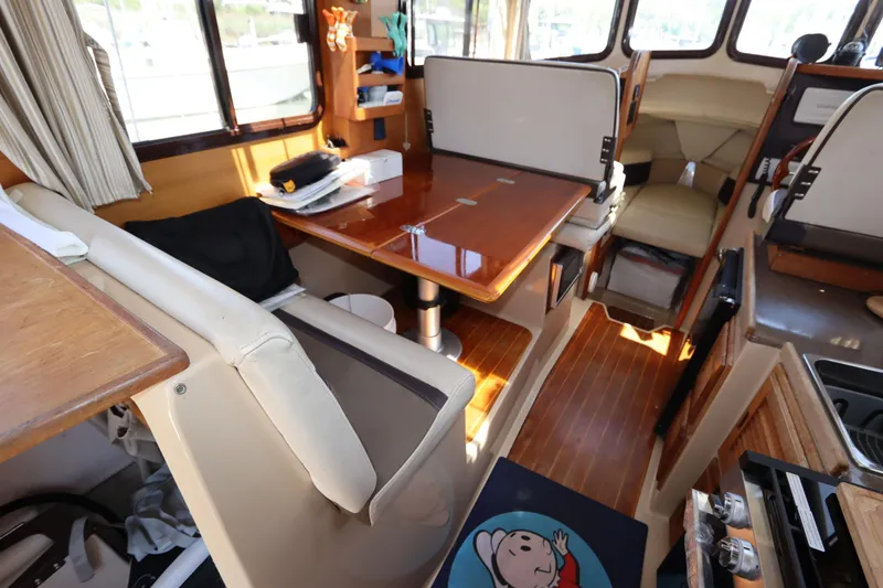 Slide: The Image of Interior of 2015 Ranger Tugs R-27 boat with seating and wooden table. - 66