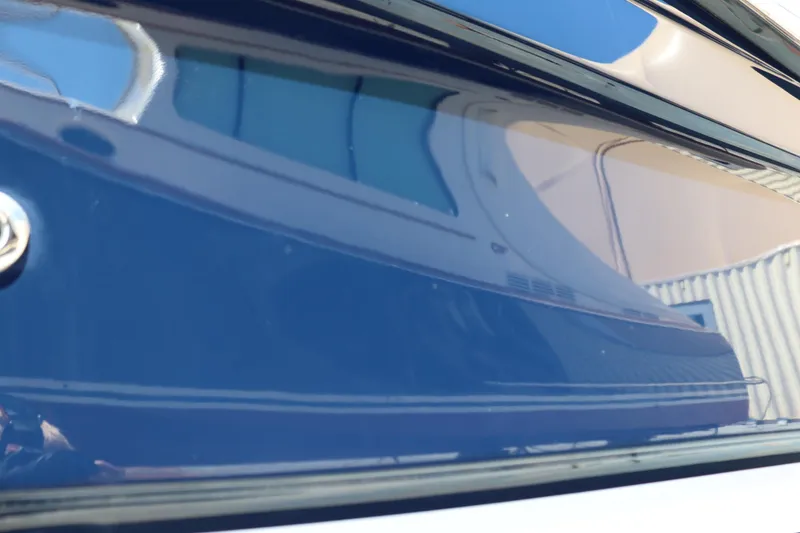 Slide: The Image of Close-up of a 2015 Ranger Tugs R-27 boat hull with reflective blue surface. - 7