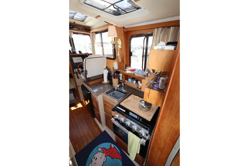 Slide: The Image of Interior of 2015 Ranger Tugs R-27 boat featuring a compact kitchen area. - 72