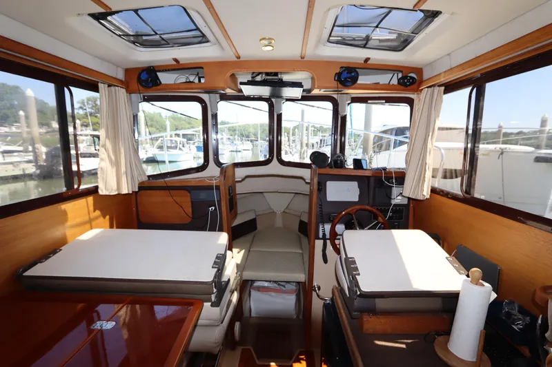 Slide: The Image of Interior of 2015 Ranger Tugs R-27 boat with wood accents and marina view. - 73