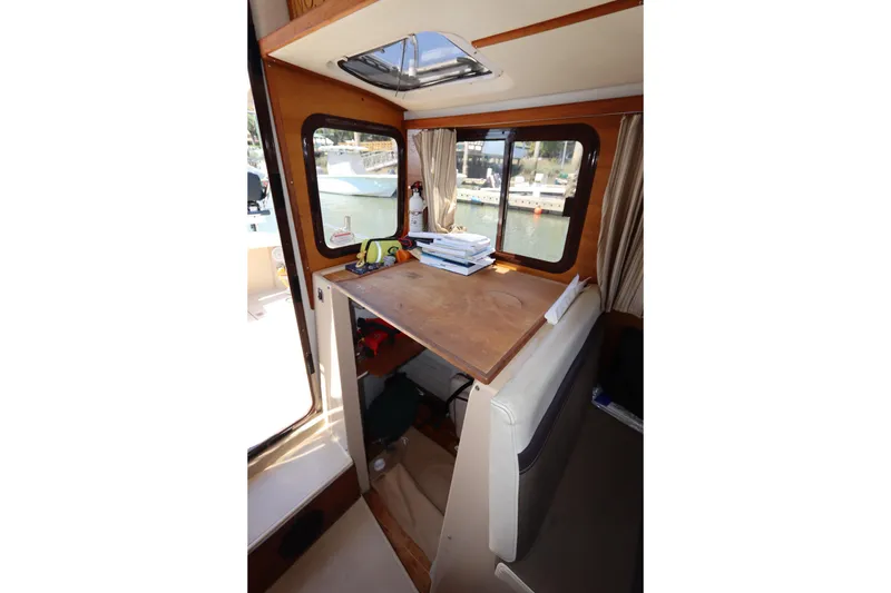 Slide: The Image of Interior of 2015 Ranger Tugs R-27 with wooden table and window view. - 91