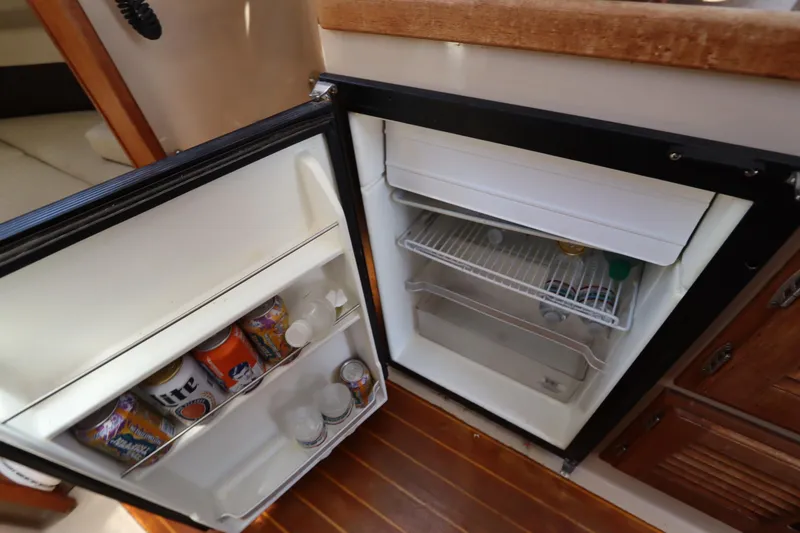 Slide: The Image of Compact refrigerator inside 2015 Ranger Tugs R-27, stocked with beverages and essentials. - 94