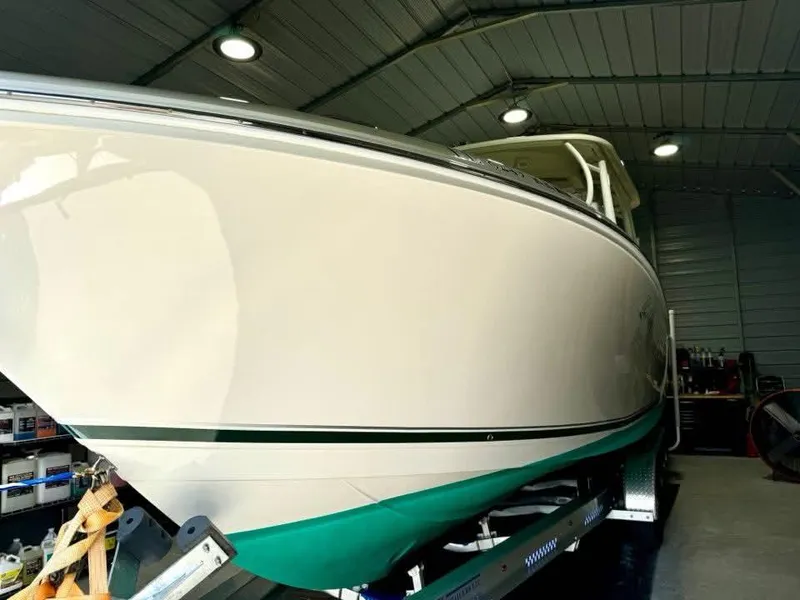 Slide: The Image of 2018 Sailfish 325 DC boat in a well-lit indoor storage facility. - 15