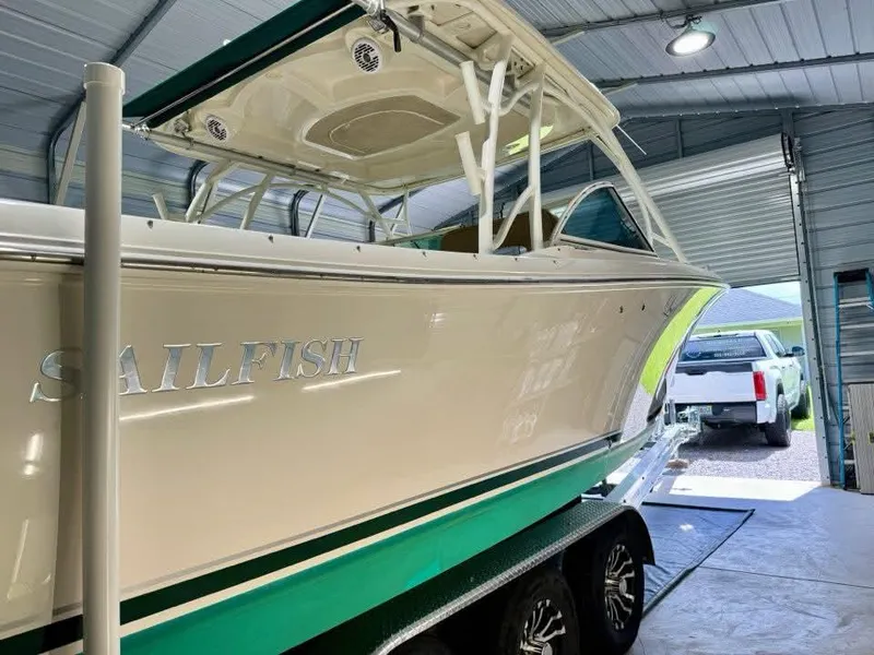 Slide: The Image of 2018 Sailfish 325 DC boat in garage, white and green, on trailer. - 17