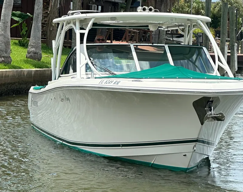Slide: The Image of 2018 Sailfish 325 DC boat docked in a scenic waterfront setting. - 26