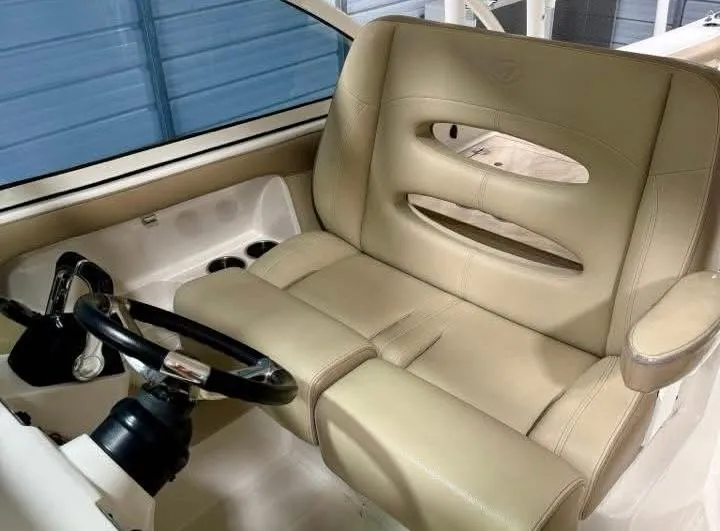 Slide: The Image of 2018 Sailfish 325 DC boat interior with beige leather seating and steering wheel. - 9