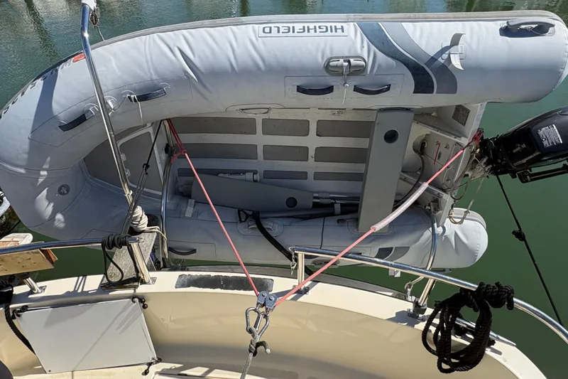 Slide: The Image of Inflatable dinghy secured on a 2004 Nordic Tug 32 boat, featuring a mounted outboard motor. - 10