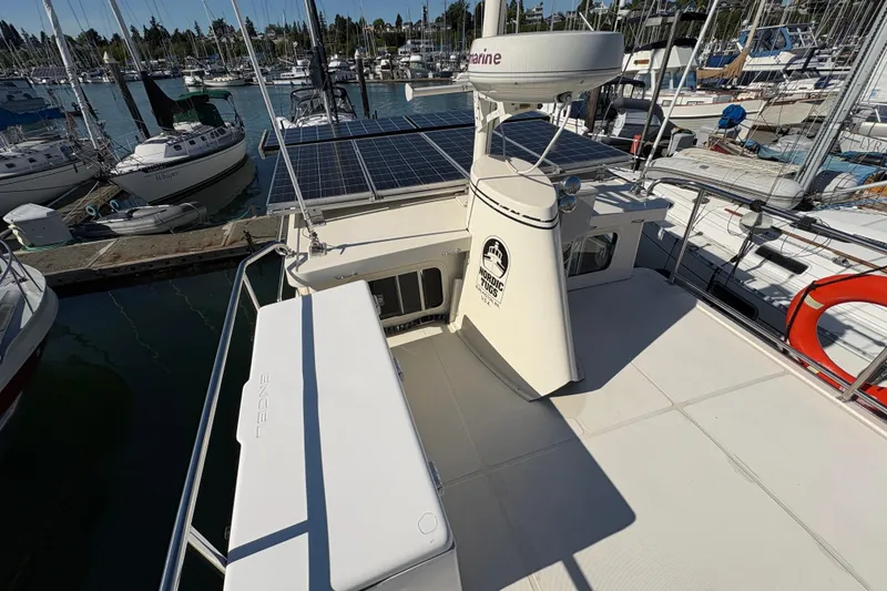Slide: The Image of 2004 Nordic Tug 32 with solar panels docked at a marina. - 11