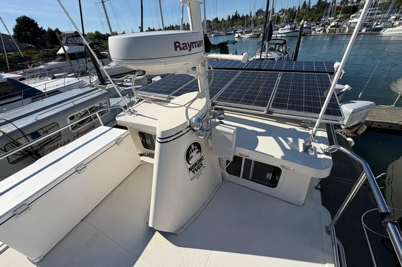 Slide: The Image of 2004 Nordic Tug 32 with solar panels docked at a marina. - 12