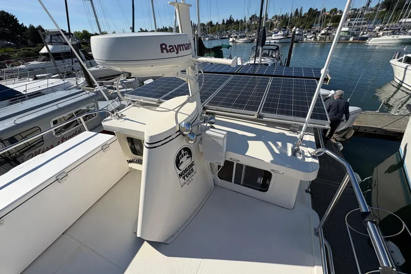 Slide: The Image of 2004 Nordic Tug 32 with solar panels docked at a marina. - 13