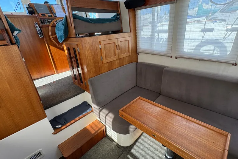 Slide: The Image of Cozy interior of a 2004 Nordic Tug 32 with wooden accents and seating area. - 17
