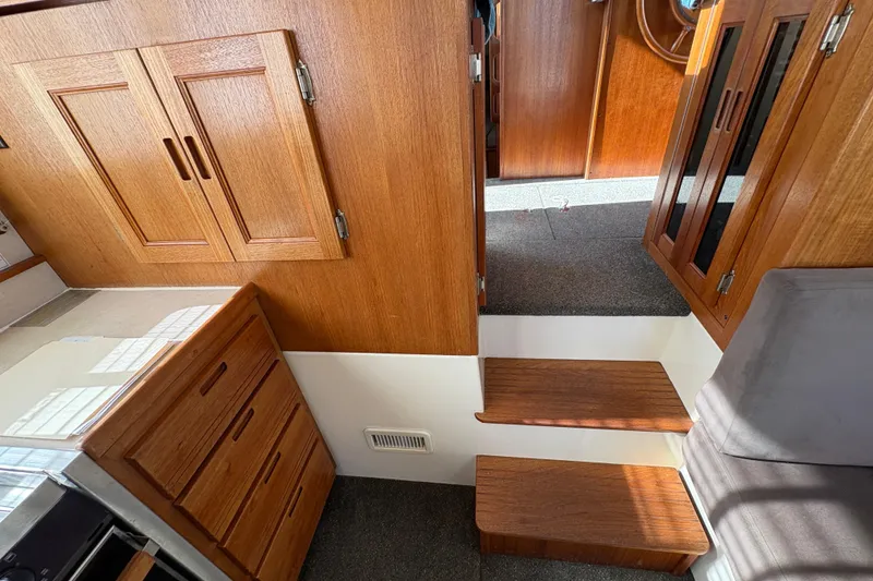 Slide: The Image of Interior of 2004 Nordic Tug 32, featuring wooden cabinetry and carpeted steps. - 23