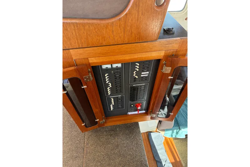 Slide: The Image of Electrical panel inside a 2004 Nordic Tug 32 boat with wooden cabinetry. - 24