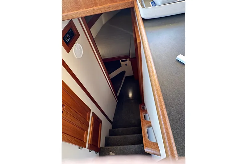 Slide: The Image of Interior view of 2004 Nordic Tug 32, featuring wooden stairs and cozy cabin space. - 29