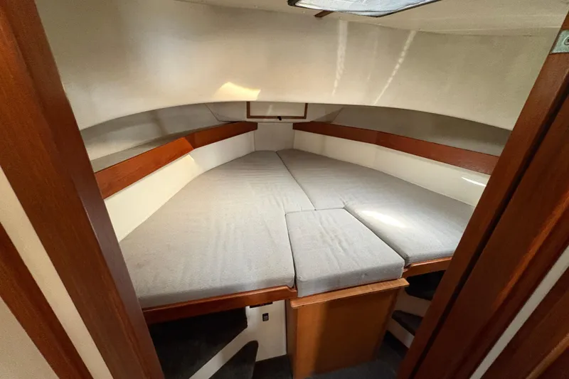 Slide: The Image of Cozy cabin interior of a 2004 Nordic Tug 32 with cushioned berth and wooden accents. - 30