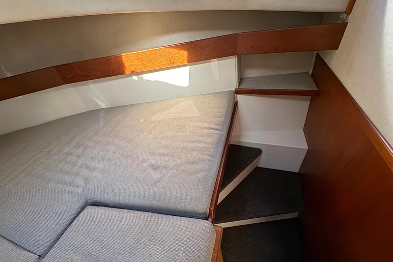 Slide: The Image of Cozy interior cabin of a 2004 Nordic Tug 32 with cushioned seating and wooden accents. - 31