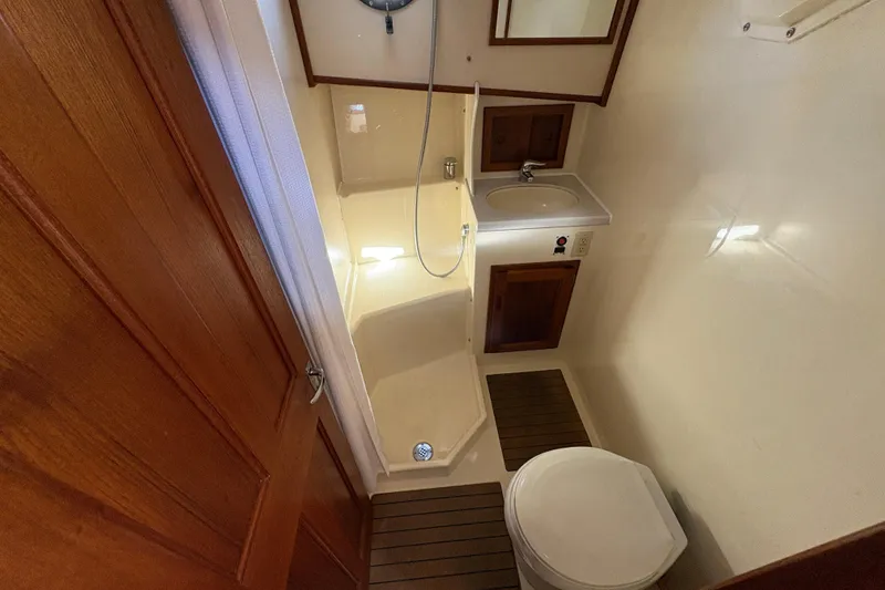 Slide: The Image of Bathroom interior of a 2004 Nordic Tug 32, featuring shower, sink, and toilet. - 35