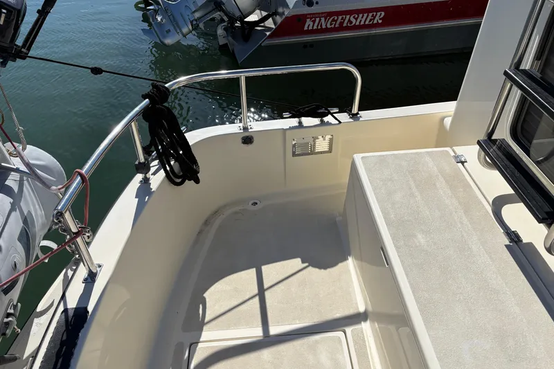 Slide: The Image of Nordic Tug 32 (2004) boat deck with railing and mooring lines, docked near water. - 8