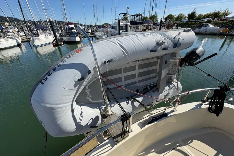 Slide: The Image of Inflatable dinghy mounted on a 2004 Nordic Tug 32 in a marina setting. - 9