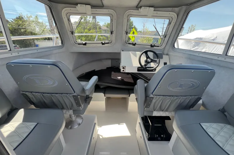 Slide: The Image of Interior of 2026 Defiance Admiral 220 EX boat, featuring helm and seating area. - 11