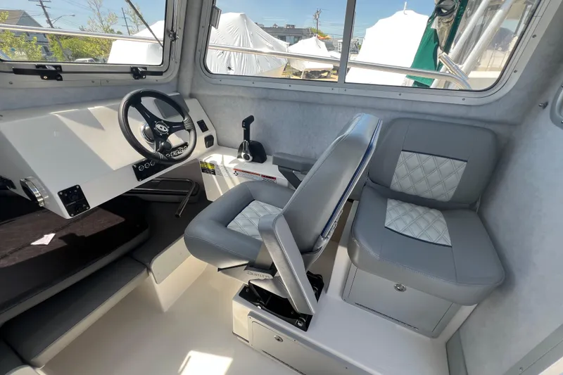 Slide: The Image of Interior of 2026 Defiance Admiral 220 EX boat with modern steering and seating. - 12