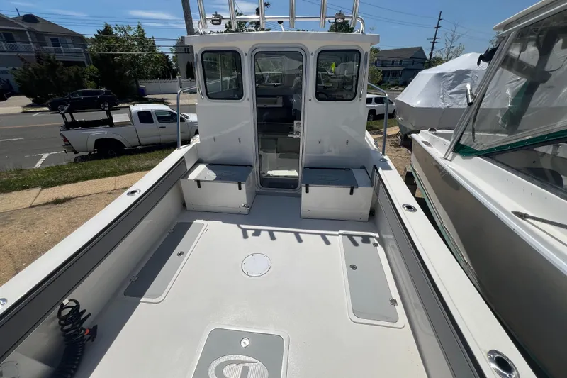 Slide: The Image of 2026 Defiance Admiral 220 EX boat deck with cabin, parked outdoors. - 9