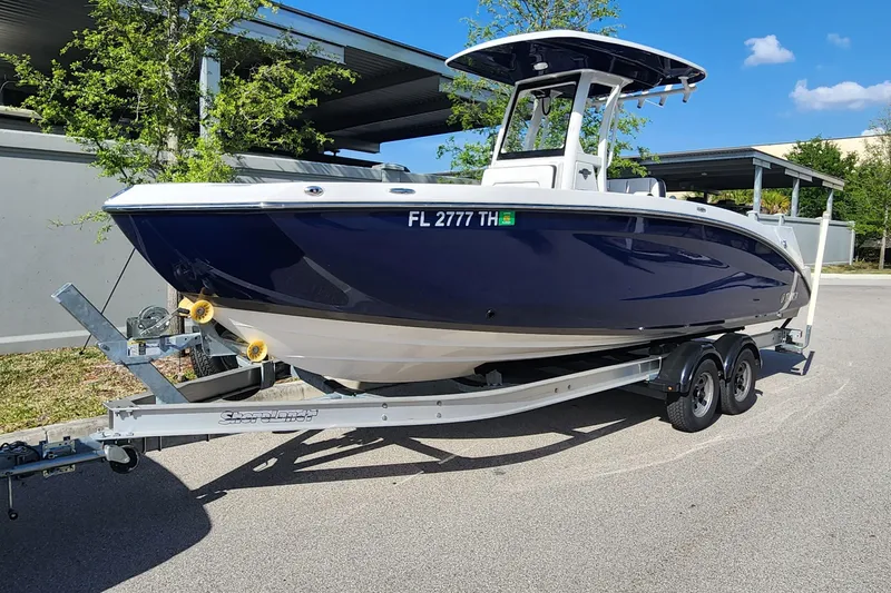 The Image of 2022 Yamaha 255 FSH Sport E boat on trailer, parked outdoors. - 1