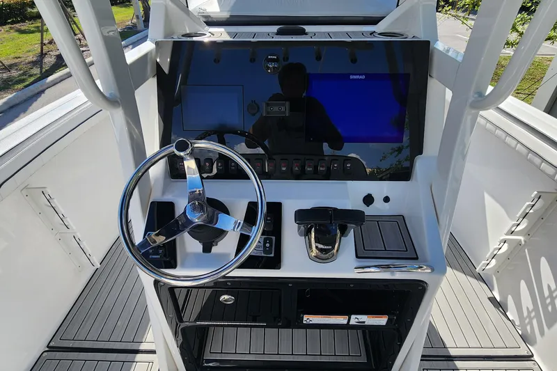 Slide: The Image of 2022 Yamaha 255 FSH Sport E boat dashboard with steering wheel and controls. - 11