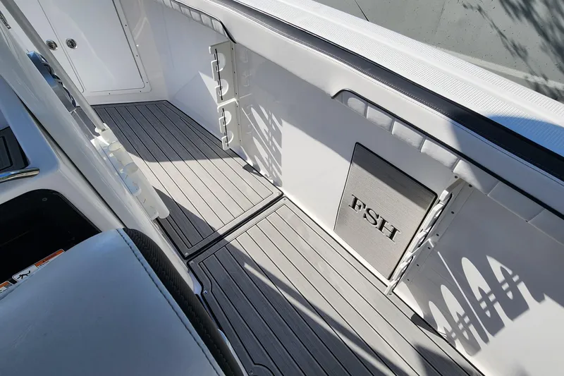 Slide: The Image of 2022 Yamaha 255 FSH Sport E boat interior with sleek deck and storage compartments. - 14