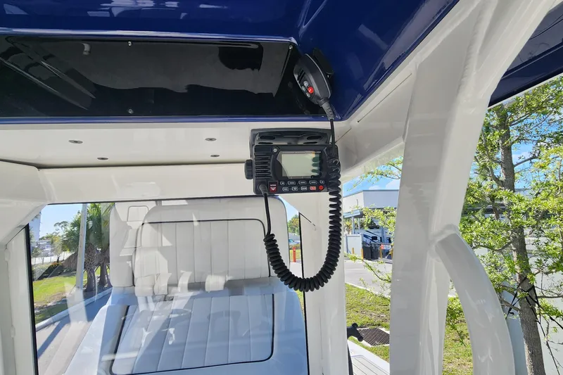 Slide: The Image of 2022 Yamaha 255 FSH Sport E boat interior with mounted radio and white seating. - 18