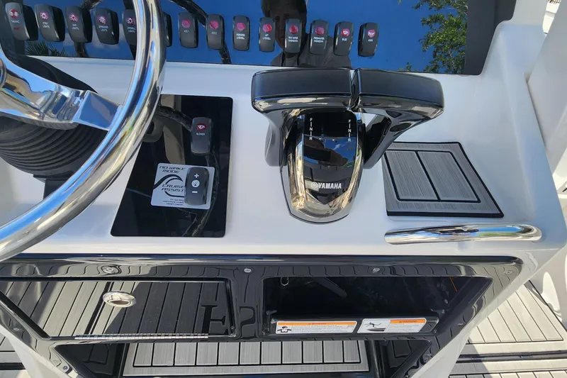 Slide: The Image of Control panel of 2022 Yamaha 255 FSH Sport E boat with steering wheel and throttle. - 19